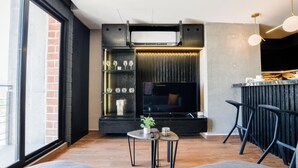 A modern living room with a large TV, a fireplace, and a bar area. - Barrio Vergel (Monterrey)