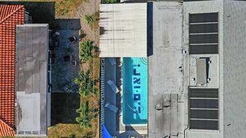 Una vista aerea di un edificio con tetto piatto, un grande cartello con la scritta 'LIXI' e un'area recintata con un piccolo prato.