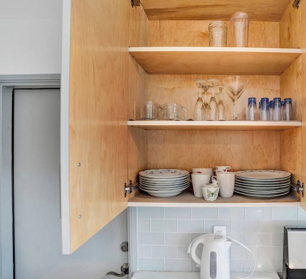 A kitchen with wooden cabinets, a coffee maker, and various kitchenware.