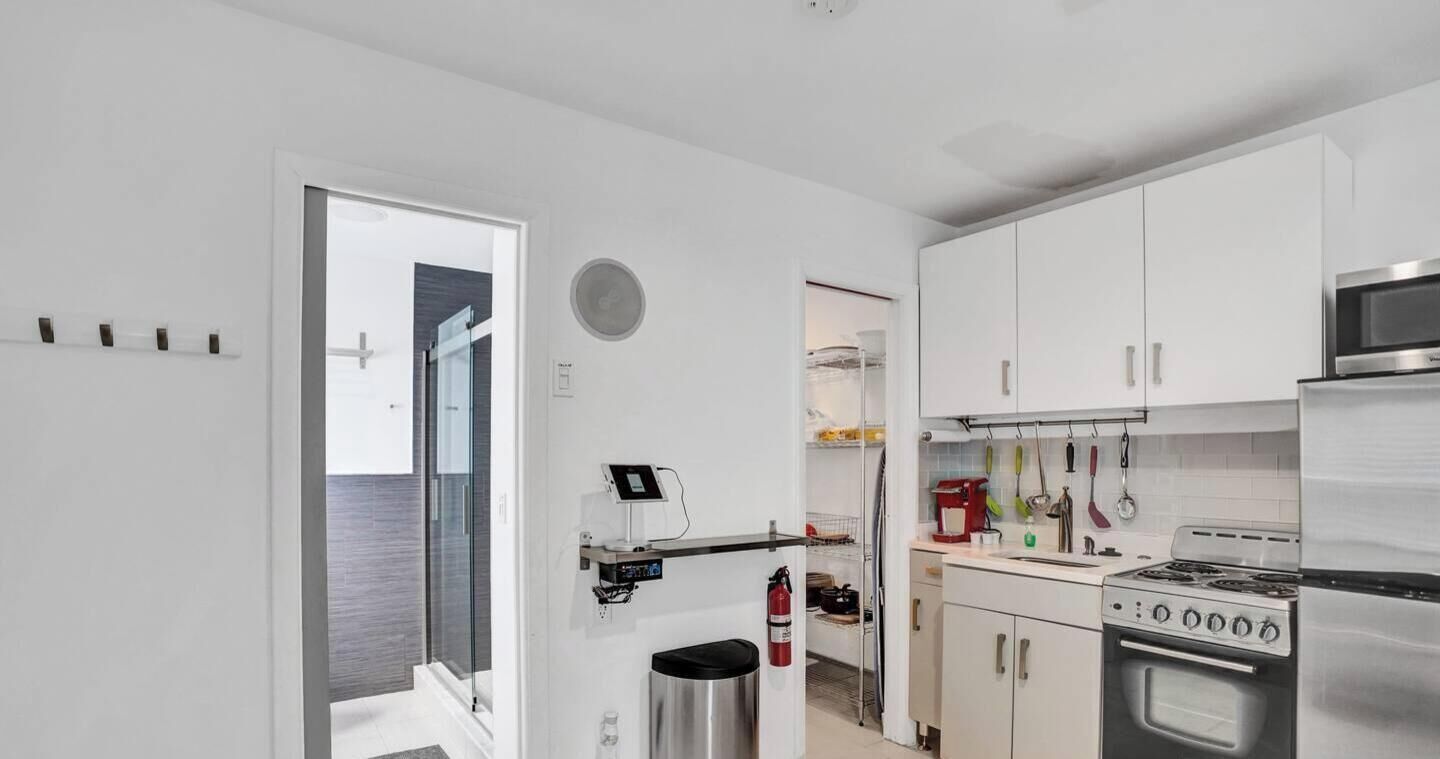 A modern kitchen with white cabinets, a stainless steel stove, and a microwave.