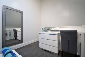 A bedroom with a large mirror, a bedside table with a lamp, and a chair. - Loft w/queen bed & steps to Hollywood Beach (Hollywood)