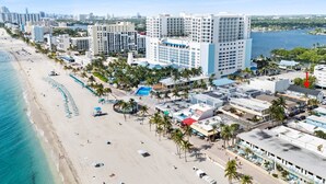 Ein Küstenhotel mit mehreren Gebäuden, einem Strand und einer Marina.