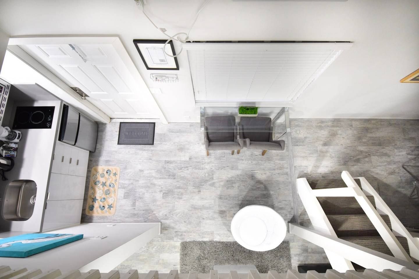 A compact kitchen with a built-in oven, a coffee machine, and a small refrigerator.