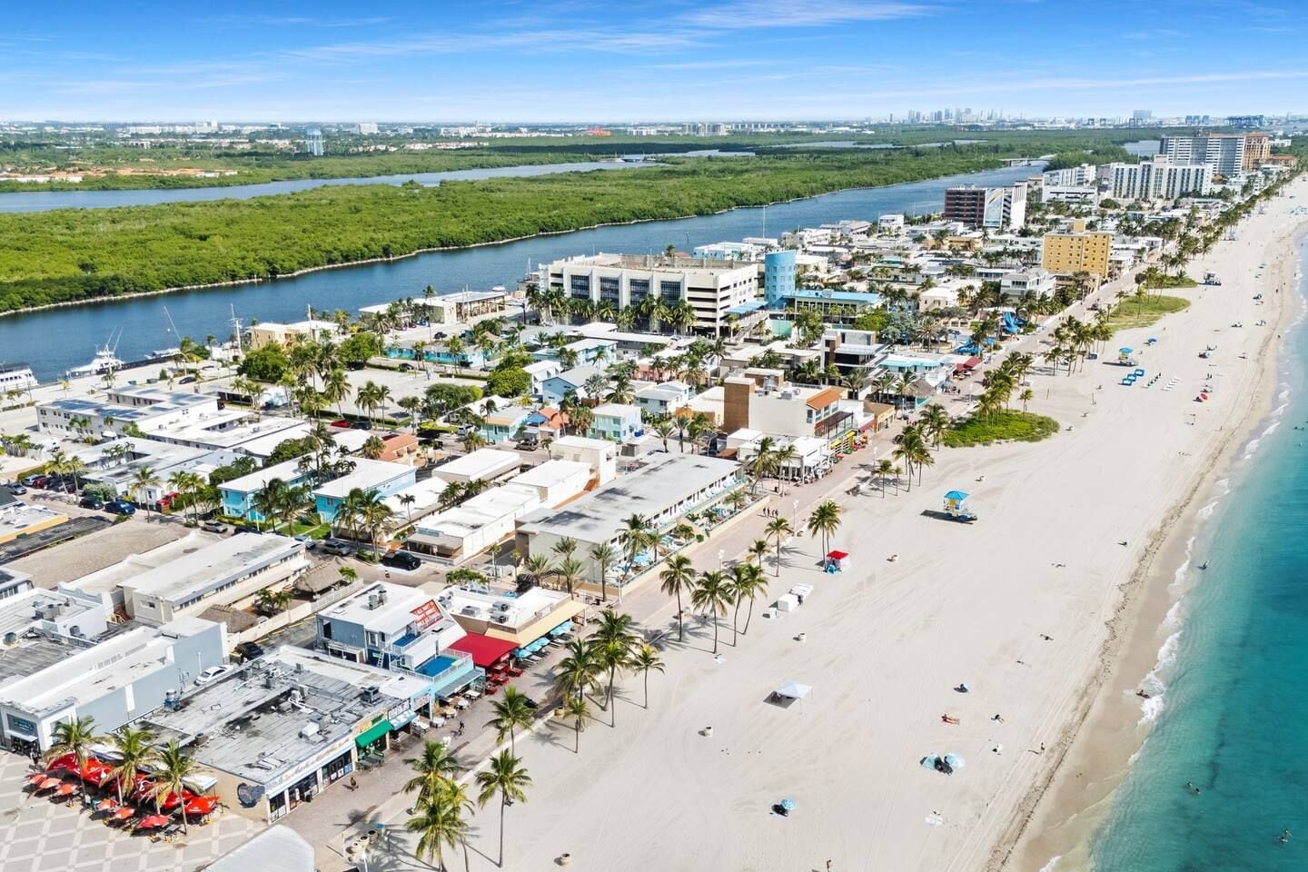 A coastal cityscape with a beachfront, buildings, and a river.