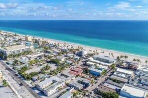 An aerial view of a coastal city with a beach, buildings, and roads. - Renovated studio w/ ocean views & boardwalk steps (Hollywood)