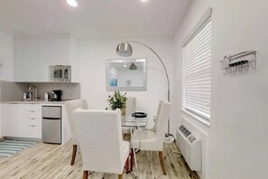 A modern kitchen with white cabinets, a built-in microwave, and a stainless steel refrigerator. - Renovated studio w/ ocean views & boardwalk steps (Hollywood)