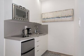 A compact kitchen with a built-in microwave, coffee maker, and stainless steel refrigerator. - Modern apartment w/beach steps & parking (Hollywood)