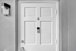 A white door with a keyhole and a doorbell. - Spacious 2BR condo w/ beach access (Hollywood)