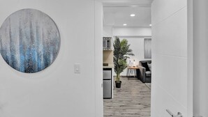 A modern interior with a large abstract painting, a kitchen area, and a dining space. - Cozy 2BR aparthotel near hollywood boardwalk (Hollywood)