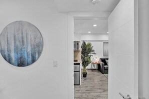 Ein modernes Interieur mit einem großen abstrakten Gemälde, einer Küchenzeile und einem Essbereich.