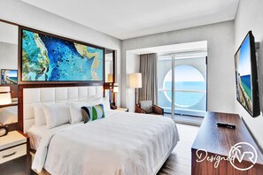 A hotel room with a large bed, a desk, a TV, and a view of the sea. - 1BR condo w/ hot tub & gym access (Fort Lauderdale)
