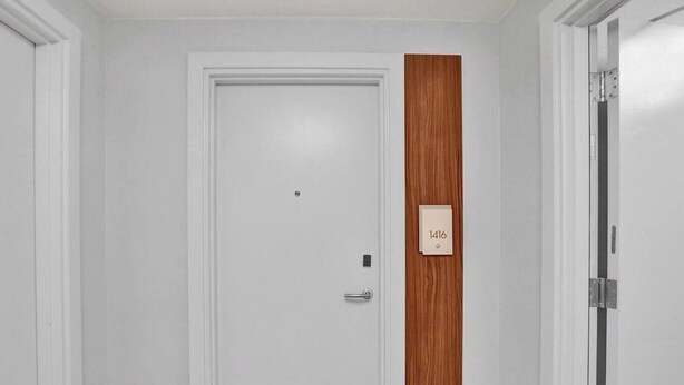 Eine weiße Tür mit einer Türschilderkennung, die Zimmer 1416 angibt.
