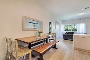 Ein modernes Wohnzimmer mit Essbereich, einer Couch und einer Küche.