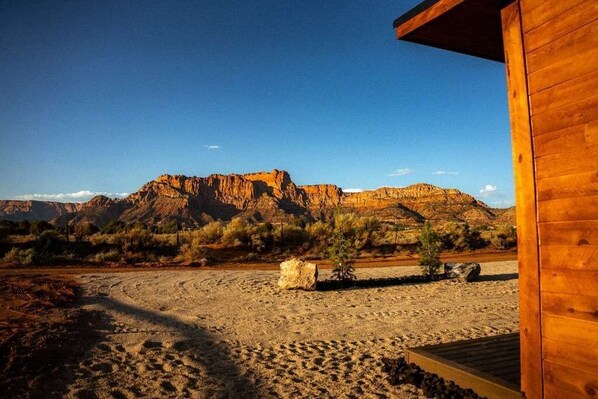 A wooden building with a view of a desert landscape and mountains.