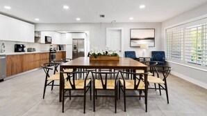 A modern kitchen with white cabinets, a wooden countertop, and stainless steel appliances. - Spacious home w/pool, fire pit & grill (Lighthouse Point)
