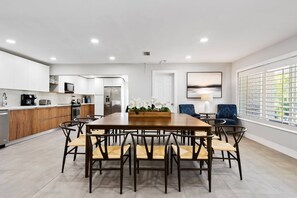 A modern kitchen with white cabinets, a wooden countertop, and stainless steel appliances. - Spacious home w/pool, fire pit & grill (Lighthouse Point)