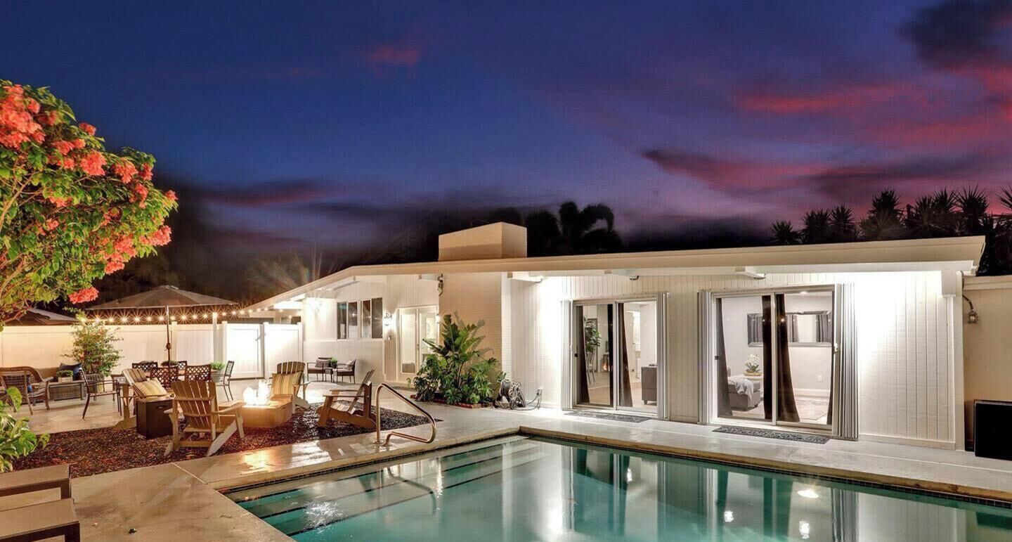 A modern outdoor pool area with a lounge, seating, and a view of the pool.