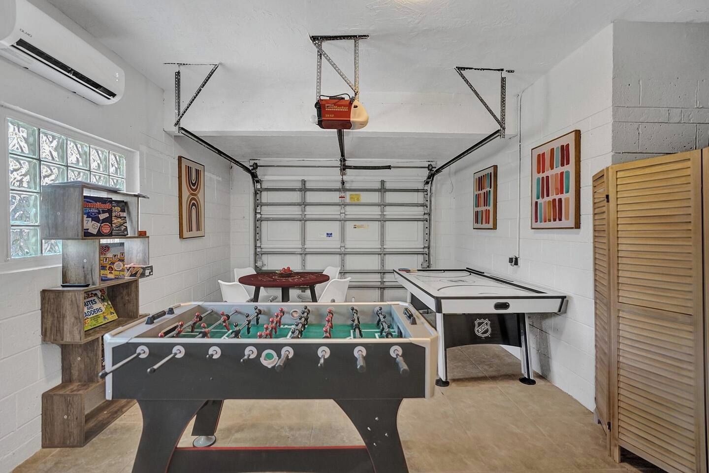 Une pièce équipée d’un baby-foot, d’une table de billard et d’une table de ping-pong.