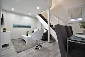 Ein modernes Interieur mit Treppe, Essbereich und Wohnraum.
