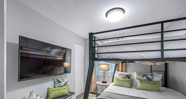 A bunk bed room with a television, bedside lamps, and a small table. - Waterfront - Private Pool - Game Room (Largo)