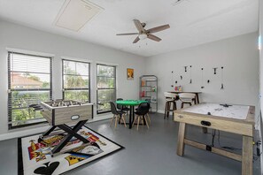 A room with a foosball table, a green table, and a foosball table with a colorful mat. - Pool - Soccer - Movie Room - Game Room - Sleeps 20 (Largo)