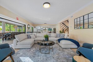 A spacious living area with a sectional sofa, a coffee table, and a dining area with a large table and chairs. - Pool - Soccer - Movie Room - Game Room - Sleeps 20 (Largo)