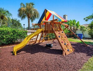 A playground with a slide, climbing wall, and swing set. - Pool - Soccer - Movie Room - Game Room - Sleeps 20 (Largo)