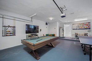 A billiards room with a pool table, a television, and a ping pong table. - Pool - Soccer - Basketball - Game Room - Sleeps 20 (Largo)