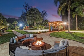 Un espacio al aire libre con una chimenea, asientos y una estructura de juegos para niños.
