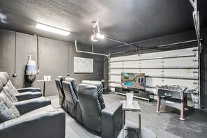 A room with a seating area, a foosball table, and a television. - Luxury villa w/pool, rooftop bar & fire pit (Pompano Beach)