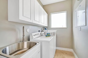 A compact kitchen with a stainless steel sink, a built-in oven, and a window above the countertop. - Luxury villa w/pool, rooftop bar & fire pit (Pompano Beach)