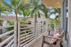 A balcony with a white railing, a wooden bench, and a patterned cushion. - Luxury villa w/pool, rooftop bar & fire pit (Pompano Beach)