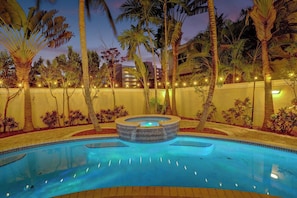 A swimming pool with a hot tub, surrounded by palm trees and a wall with lights. - Luxury villa w/pool, rooftop bar & fire pit (Pompano Beach)