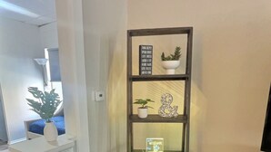Una estantería de esquina con varios estantes, cada uno con adornos y pequeñas plantas.