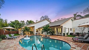 A residential property with a swimming pool, outdoor seating, and a covered patio area. - Villa w/Pool, Firepit & BBQ (Dania Beach)