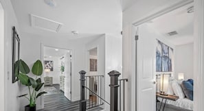 A modern interior with a staircase, a hallway leading to a bedroom, and a dining area. - Pool - Basketball -Soccer - Game Room - Playground (Largo)