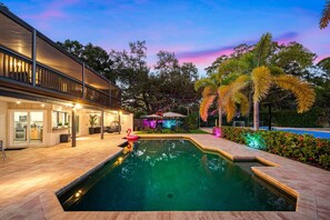 A modern house with a swimming pool, outdoor seating, and a well-lit patio area. - Pool - Pickleball - Basket - Soccer - Game Room! (Seminole)