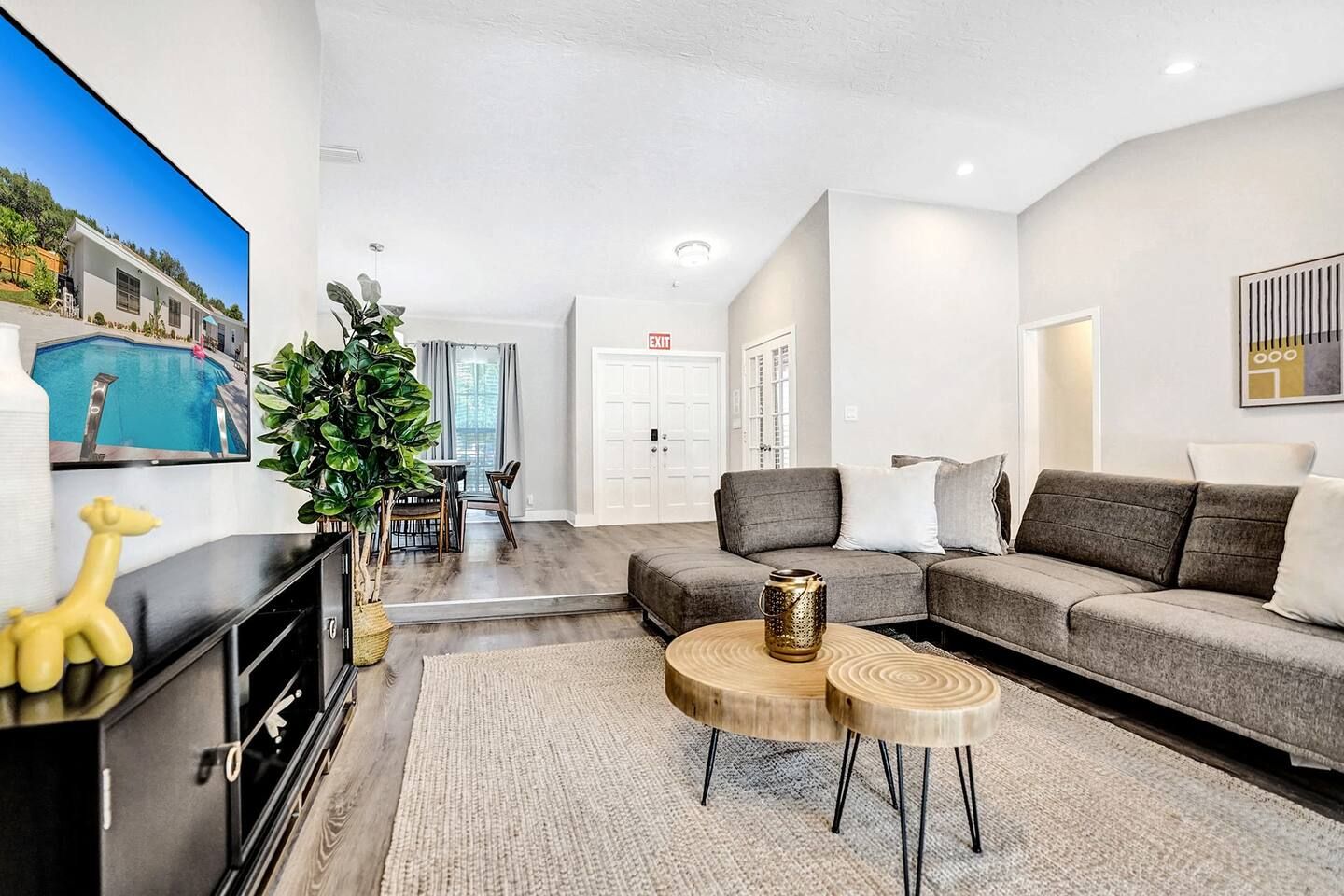 A modern living room with a grey sofa, a coffee table, and a TV.
