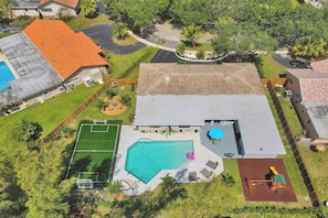 A residential property with a swimming pool, a fenced yard, and a tennis court. - Family home w/pool & mini-soccer field (Davie)