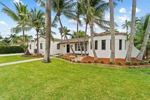 A modern house with a white exterior, surrounded by a well-maintained lawn and palm trees. - Spacious home w/ heated pool & jacuzzi (Hollywood)