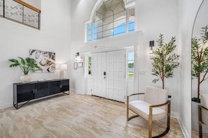 A spacious entryway with a black console, a white door, and a seating area with a chair. - Pool - Pickleball - Soccer - Basket - Sleeps 18! (Tampa)