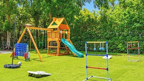 A playground with a slide, swings, and climbing structures. - Pool - Pickleball - Soccer - Basket - Sleeps 18! (Tampa)