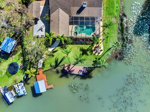 A house with a swimming pool, a dock, and a boat. - Waterfront - Pool - Pickleball - Basket -Sleeps 18 (Westchase)