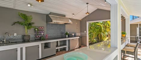 A modern kitchen with a large island, a built-in oven, and a view of the outdoors.