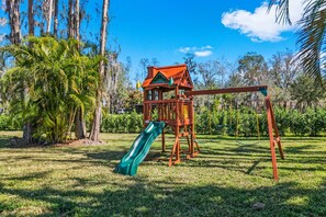 A playground with a slide and swings. - Waterfront - Pool - Pickleball - Basket -Sleeps 18 (Westchase)