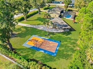 A residential area with a tennis court, a swimming pool, and a covered patio. - Private Pool - Pickleball - Game Room - Sleeps 18! (Westchase)