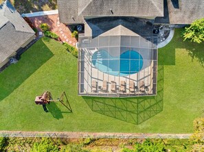 A residential property with a swimming pool, a lawn, and a person operating a lawn mower. - Private Pool - Pickleball - Game Room - Sleeps 18! (Westchase)