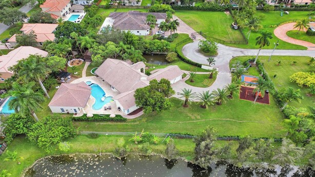 A residential area with houses, a swimming pool, and a curved driveway.