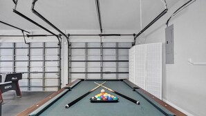 A pool table with balls and cues, a pool table cover, and a pool table with a wooden frame.