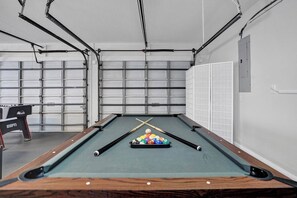 A pool table with balls and cues, a pool table cover, and a pool table with a wooden frame. - The Grand Luxe 8Br Villa w Pool and Basketball (Pembroke Pines)
